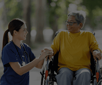A nurse walking outdoors beside a participant in a wheelchair