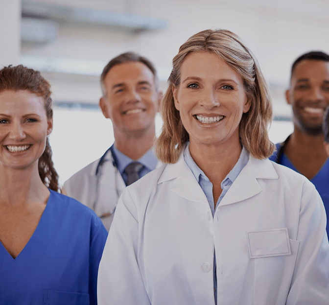 Four smiling Unicare care professionals standing together in a clinic