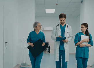 A doctor and two nurses reviewing notes in a corridor