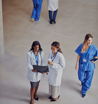 Three care staff talking in a hospital atrium, seen from above