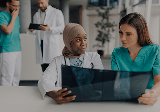 Two clinicians examining an X-ray together at a desk