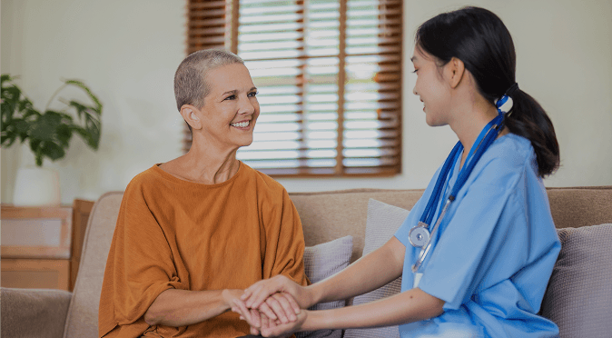 A support worker sitting with a smiling client at home